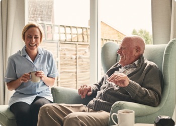 carer laughing with elderly man