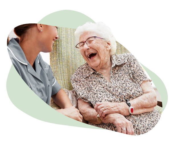 elderly woman laughing with carer