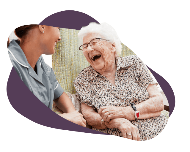 elderly woman laughing to carer